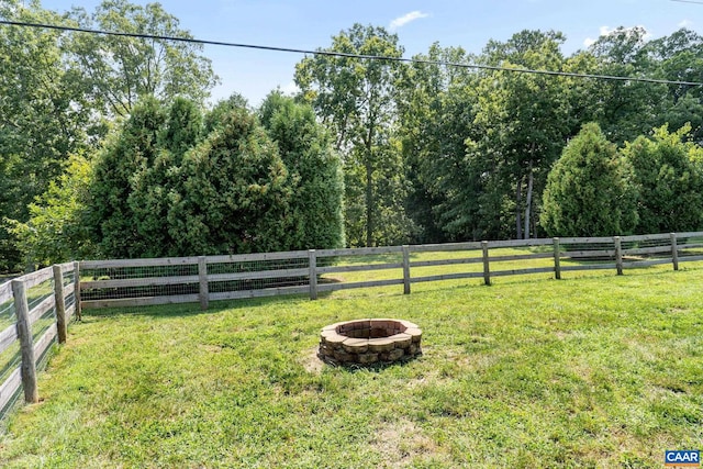 view of yard featuring an outdoor fire pit and a rural view