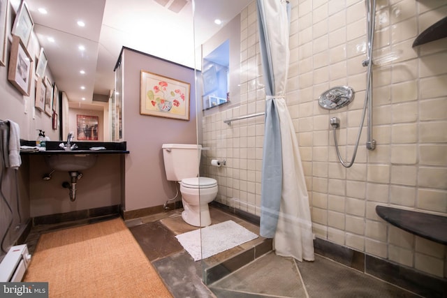 full bathroom with a baseboard radiator, tiled shower, toilet, and recessed lighting