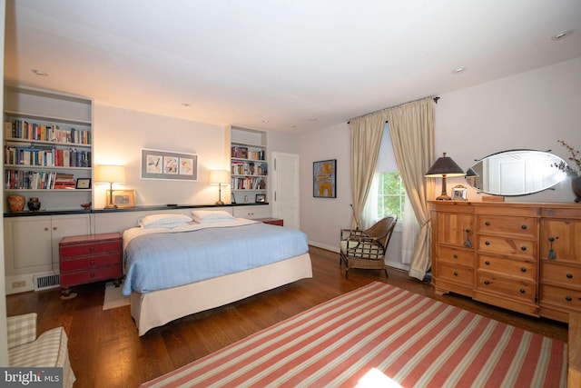 bedroom featuring wood finished floors and visible vents