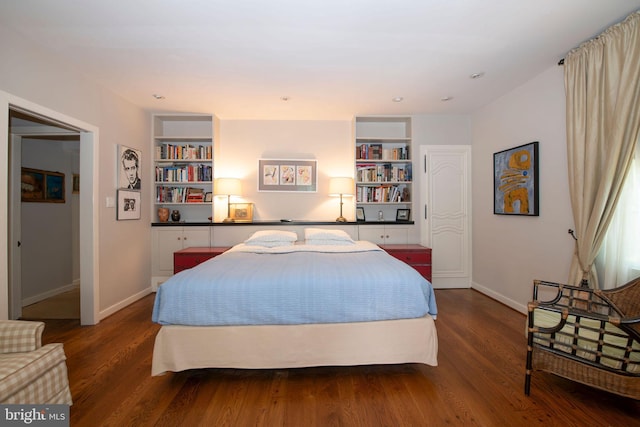 bedroom with baseboards and wood finished floors