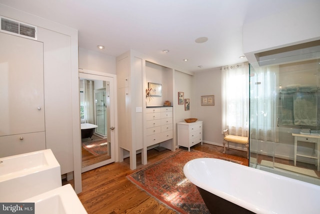 full bathroom featuring a freestanding tub, visible vents, vanity, and wood finished floors