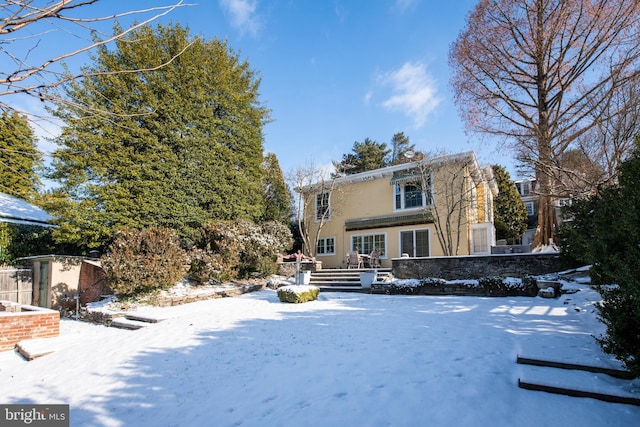 snow covered property with stucco siding