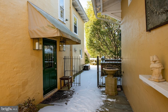 property entrance featuring fence and stucco siding