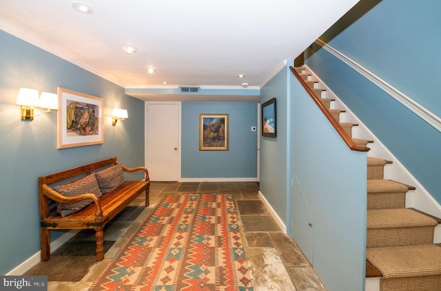 corridor featuring visible vents, baseboards, stairs, ornamental molding, and stone tile flooring