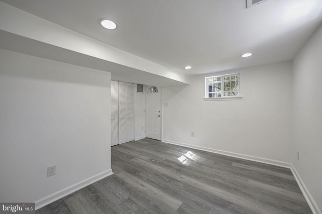 basement with dark hardwood / wood-style floors