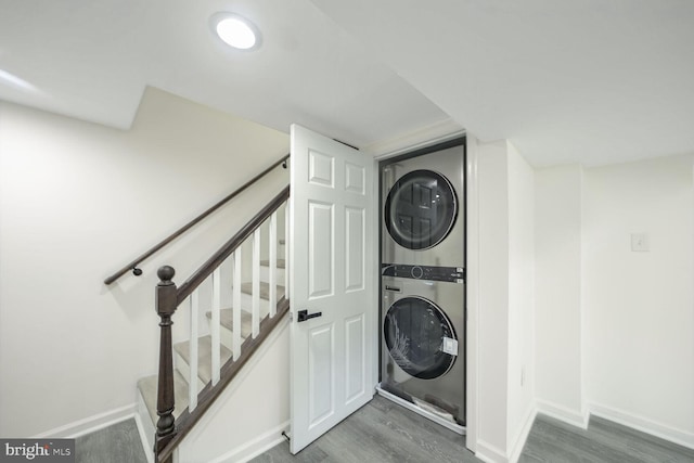 laundry room with stacked washer / drying machine and dark hardwood / wood-style floors