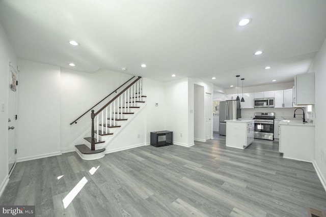 unfurnished living room with sink and hardwood / wood-style flooring