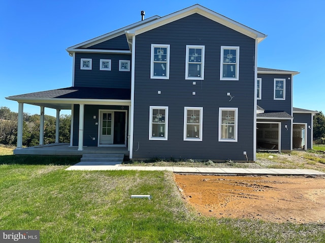 rear view of house with a porch and a lawn