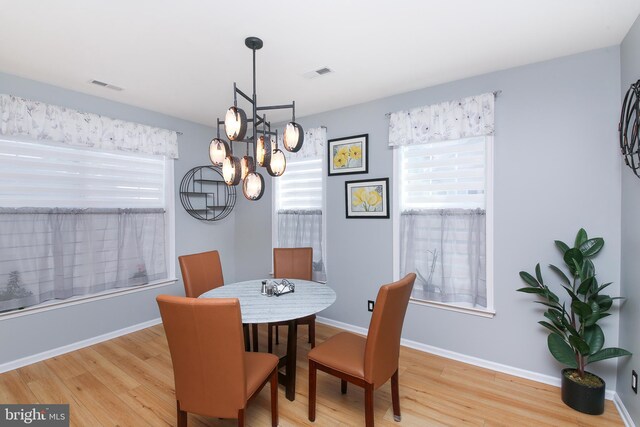 dining space with a chandelier and light hardwood / wood-style floors