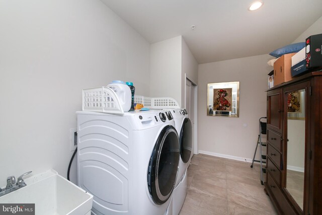 washroom featuring light tile patterned floors, independent washer and dryer, and sink