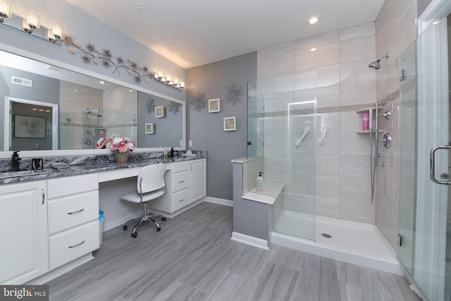 bathroom with tile patterned floors, an enclosed shower, and vanity