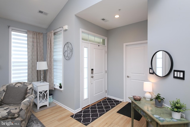 entryway featuring vaulted ceiling, light hardwood / wood-style flooring, and a wealth of natural light