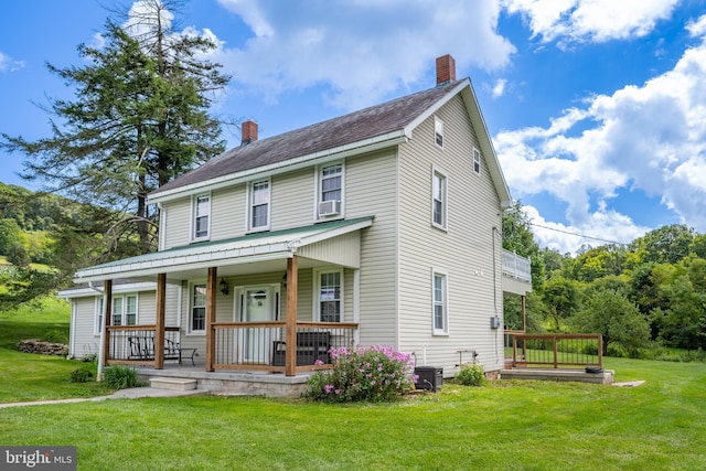 view of front of house featuring cooling unit, covered porch, a chimney, and a front lawn