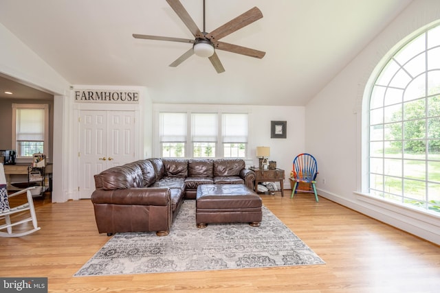 living room featuring lofted ceiling, light wood-style floors, and a ceiling fan