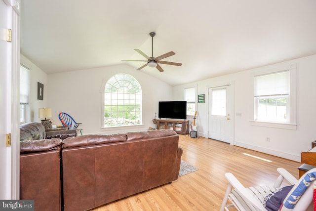 living room with light wood finished floors, ceiling fan, baseboards, and vaulted ceiling