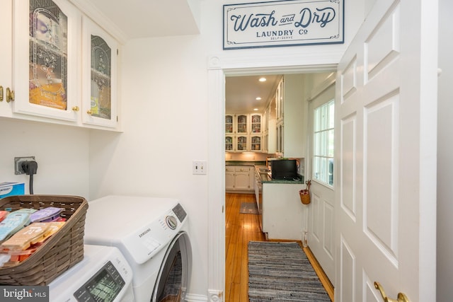 laundry room with cabinet space, recessed lighting, washer and dryer, and wood finished floors