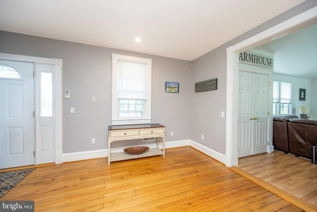 foyer featuring baseboards, wood finished floors, and recessed lighting