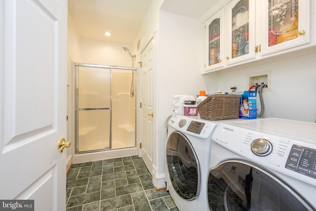 laundry area with dark tile patterned flooring, cabinets, and washer and dryer