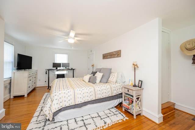 bedroom with light wood-type flooring, a ceiling fan, and baseboards