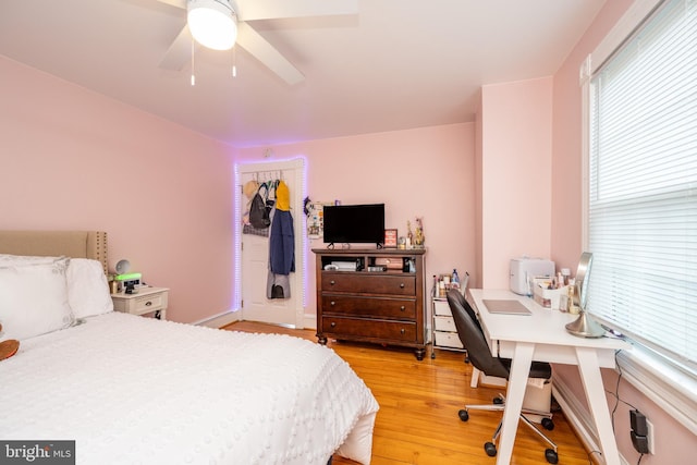 bedroom with light wood-style floors, ceiling fan, and a closet