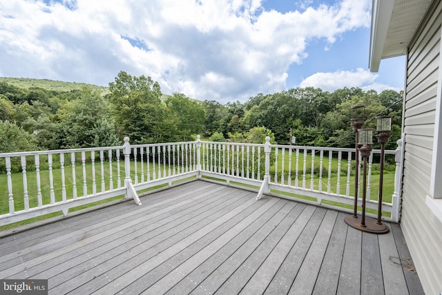 wooden terrace featuring a lawn