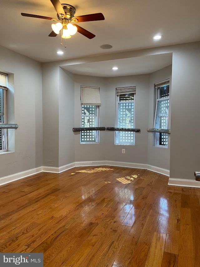 spare room featuring recessed lighting, wood finished floors, a ceiling fan, and baseboards