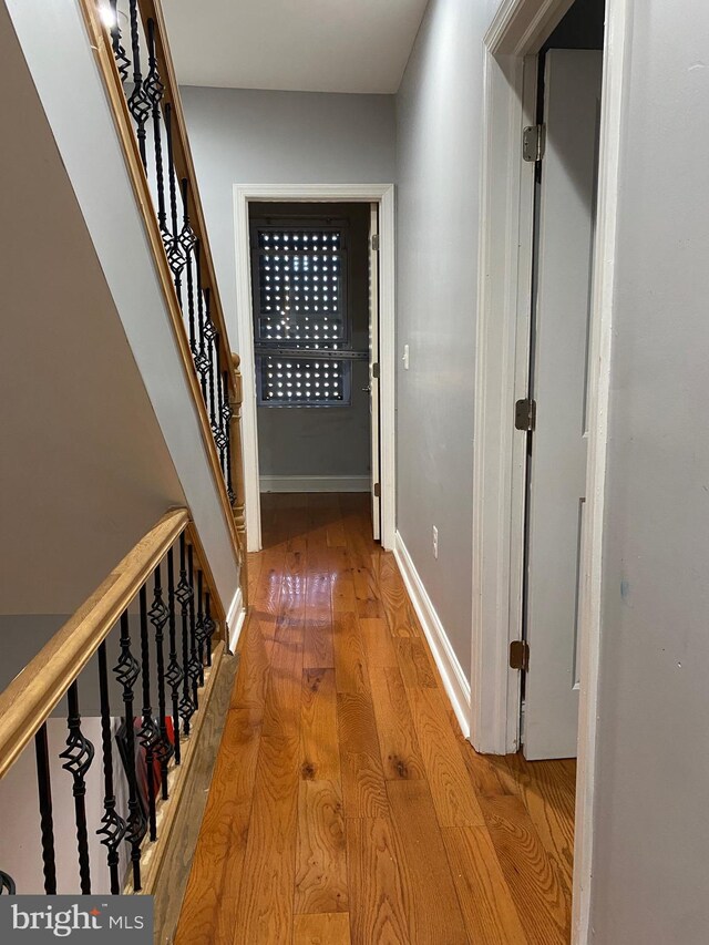 corridor with hardwood / wood-style floors