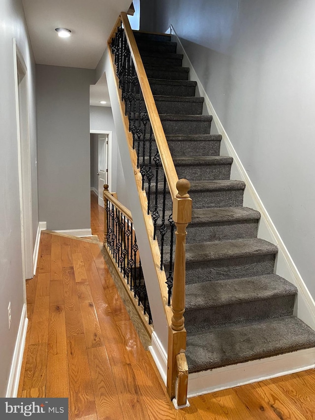 stairs with baseboards and wood finished floors