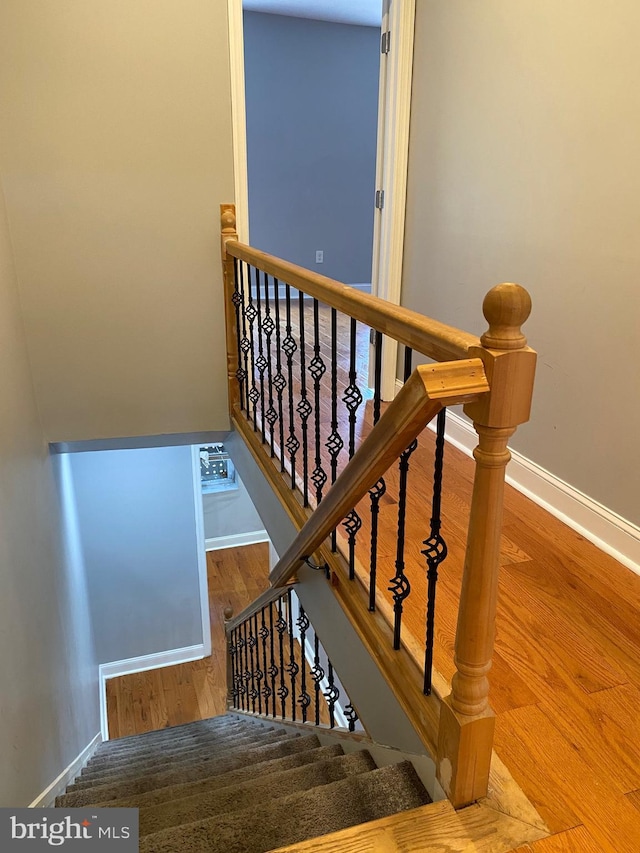 stairway featuring wood finished floors and baseboards