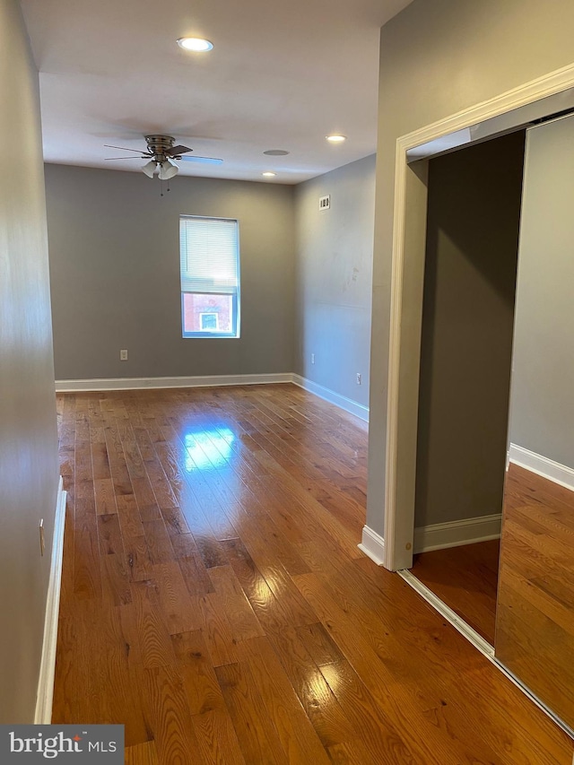 unfurnished room featuring recessed lighting, wood finished floors, a ceiling fan, and baseboards