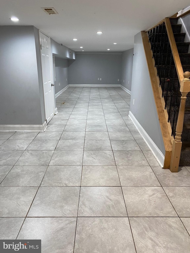 finished below grade area featuring recessed lighting, stairway, and light tile patterned floors