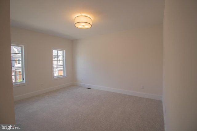 unfurnished room featuring light colored carpet