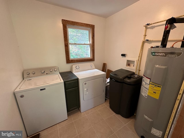 laundry room featuring water heater, cabinets, light tile patterned floors, and separate washer and dryer