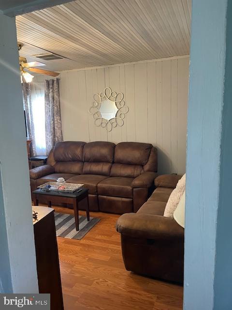 living room featuring ceiling fan and hardwood / wood-style flooring