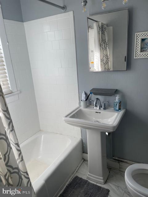 full bathroom with toilet, shower / bathtub combination with curtain, and sink