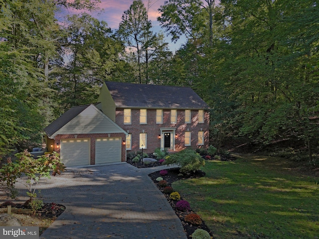 colonial house with a garage and a lawn