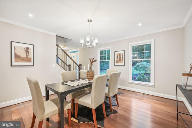 dining area featuring ornamental molding, hardwood / wood-style floors, and a chandelier