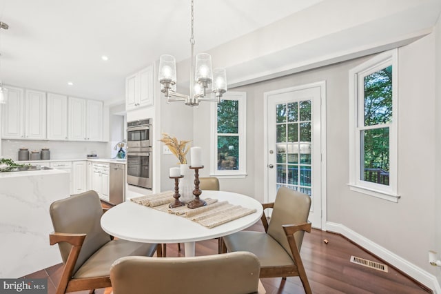 dining room with a notable chandelier and dark hardwood / wood-style floors