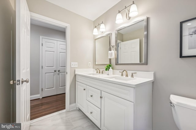 bathroom with hardwood / wood-style flooring, vanity, and toilet