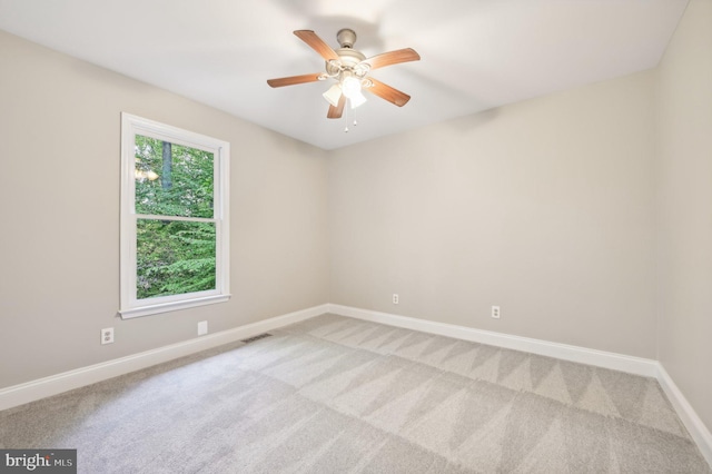 empty room featuring light colored carpet and ceiling fan