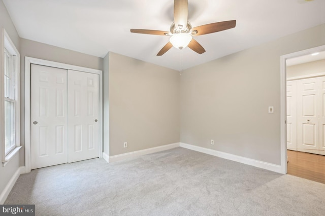 unfurnished bedroom with ceiling fan, a closet, and light carpet