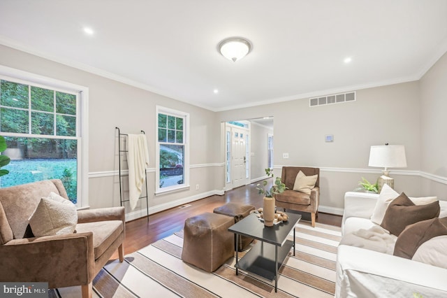 living room with crown molding, plenty of natural light, and light hardwood / wood-style flooring