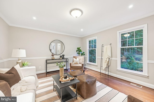 living room with plenty of natural light, crown molding, and hardwood / wood-style floors