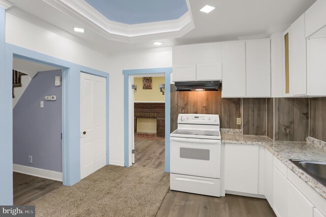 kitchen featuring a tray ceiling, wood-type flooring, white range with electric stovetop, and white cabinets