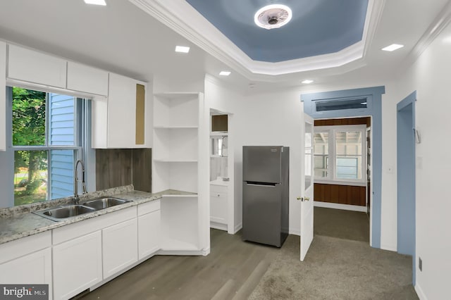 kitchen featuring white cabinets, stainless steel refrigerator, sink, wood-type flooring, and ornamental molding