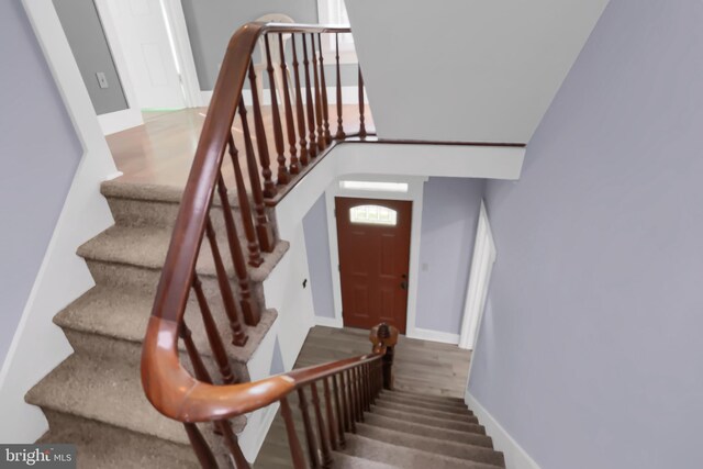 stairway featuring a high ceiling and hardwood / wood-style flooring