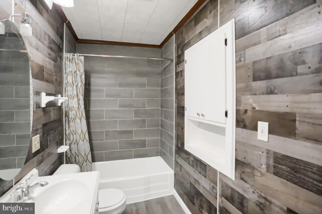 full bathroom with toilet, hardwood / wood-style floors, vanity, shower / bath combo with shower curtain, and tile walls