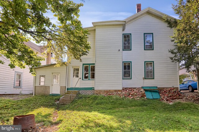 back of house featuring a lawn