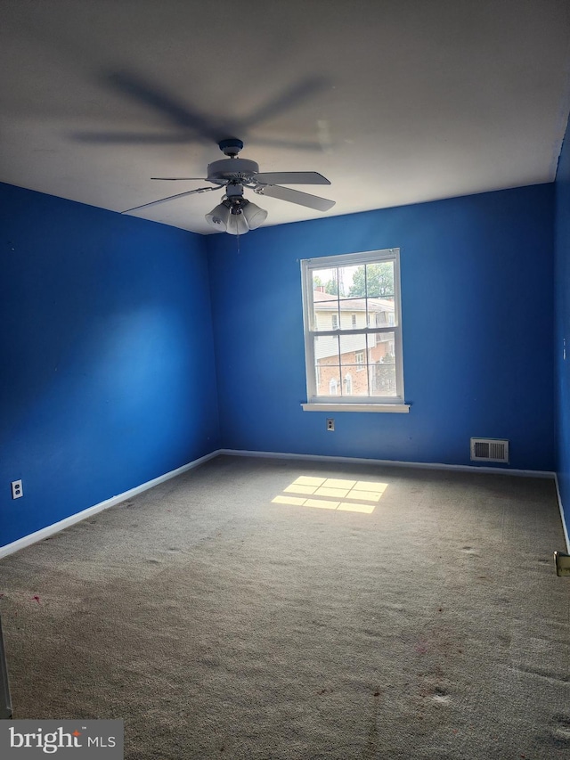 unfurnished room with ceiling fan and carpet