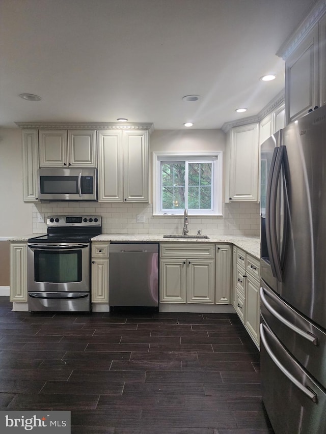 kitchen featuring backsplash, appliances with stainless steel finishes, dark hardwood / wood-style flooring, white cabinetry, and sink